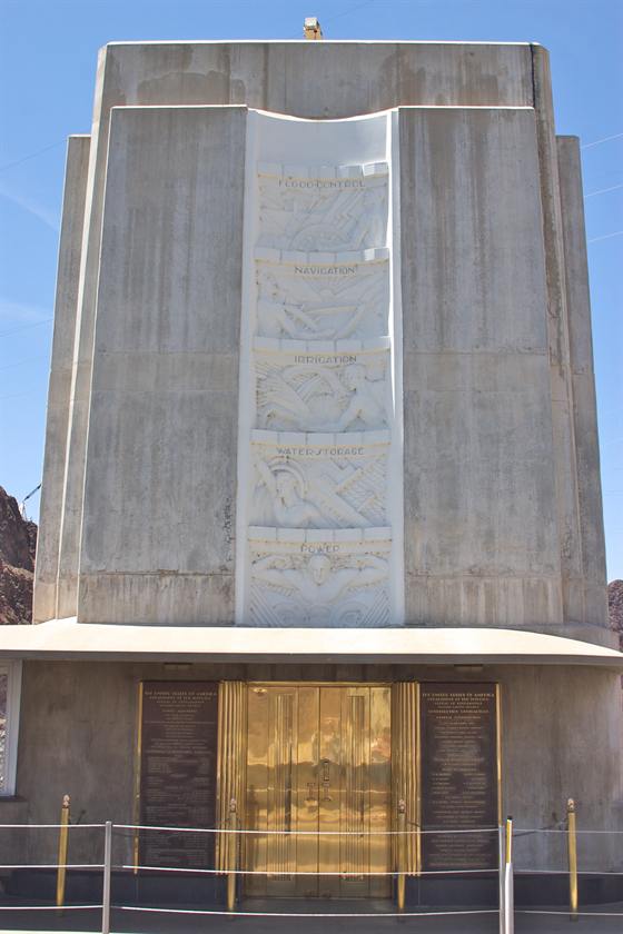 The Hoover Dam intake-tower monument — a five-story Art Deco tower whose marble panel lists Flood Control, Navigation, Irrigation, Water Storage, and Power.